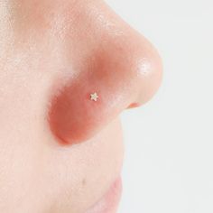 a close up of a person's nose with a tiny star piercing on it