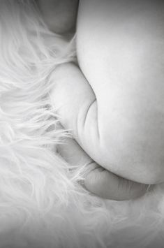 a close up of a baby's head on top of a fluffy white blanket