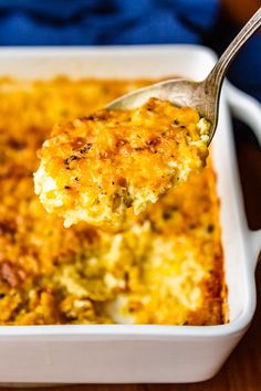 a spoon full of cheese casserole on a wooden table