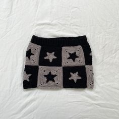 a black and white crocheted skirt with stars on it sitting on a bed