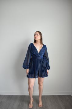 Navy Dress Romper with sparkling belt and long sleeves to dazzle at any formal event. Featuring an adjustable belt and a plunging v-neckline, you can elevate your look with sky-high heels or simply make it a more relaxed ensemble for at-home soirées. Crafted from a lightweight Polyester, this Navy Dress Romper is the epitome of grace and sophistication. Size guide: The First Model is 5'6" and wearing size Small. The Second model is wearing a size small Elegant Belted Mini Dress For Party, Party Dresses With Belted Mini Length, Glamorous Belted Dresses For Date Night, Glamorous Belted Dress For Formal Occasion, Glamorous Belted Formal Dresses, Glamorous Formal Belted Dress, Glamorous Belted Cocktail Dress, Belted Long Sleeve Mini Dress For Night Out, Party Mini Dress With Belted Surplice Neckline