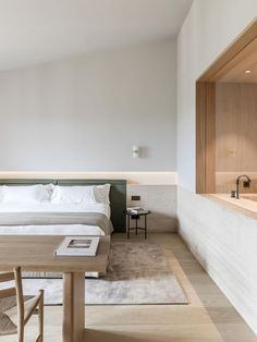 a bed sitting next to a wooden table in a bedroom