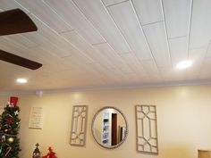 a living room filled with furniture and a christmas tree in front of a wall mounted mirror