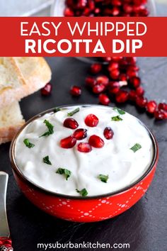 a red bowl filled with whipped ricotta dip next to cranberries and bread