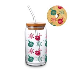 a glass jar with a straw in it and a wooden lid that has christmas decorations on it