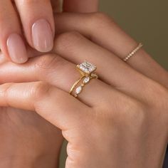 a woman's hand holding an engagement ring