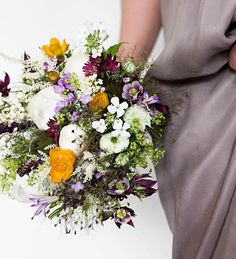 a woman holding a bouquet of flowers in her hands