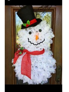 a snowman door hanger with a top hat and scarf on it's head