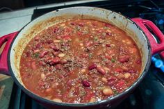 a pot filled with chili and beans on top of a stove