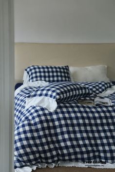 a blue and white checkered comforter on a bed