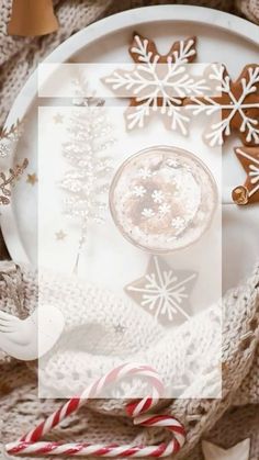 a white plate topped with a cup of coffee next to candy canes and snowflakes