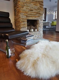 a living room filled with furniture and a fire place in the middle of it on top of a hard wood floor