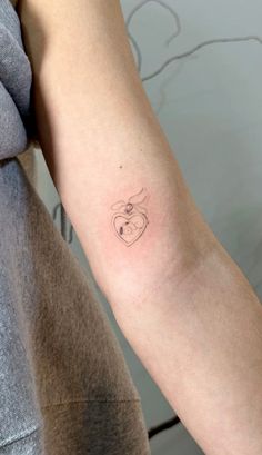 a woman's arm with a small tattoo on the left side of her arm