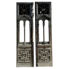 pair of ornate metal bookends with intricate designs on each side and an open door at the top