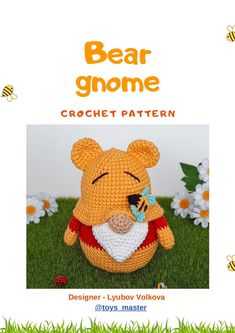 a crochet bear is sitting in the grass