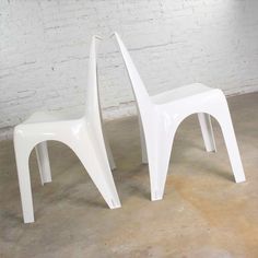 two white plastic chairs sitting next to each other