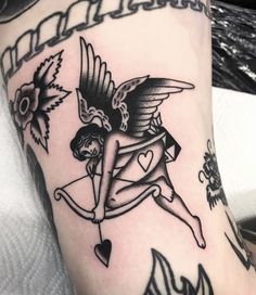 a woman with an arrow and heart tattoo on her leg