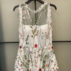 This Beautiful Dress Is A Junior Size 9 Great For Many Occasions Wether It Be Casual Or Formal ! It’s Like Brand New Warn Once For A Few Hours , Perfect Condition Back Zipper And Double Lace Layer Underneath. White Embroidered A-line Dress For Spring, Feminine Sleeveless Embroidered Spring Dress, White Sleeveless Dress With Floral Applique, Feminine Sleeveless Mini Dress With Floral Embroidery, Feminine Summer Dress With Intricate Embroidery, Summer Wedding Mini Dress With Floral Embroidery, Embroidered A-line Mini Dress For Spring, Embroidered Mini Dress For Summer Garden Party, Sleeveless Embroidered Mini Dress For Garden Party