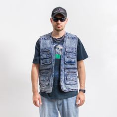 Vintage 90's cargo style denim vest in stonewashed blue - with a front zip - features four main pockets and several smaller ones - materials: denim SIZE from the tag: L MEASUREMENTS chest: 44 inches (112 cm) length: 29 inches (73 cm) The model is 6'1" (186 cm), measures 41-35-39 (104-88-100 cm) and typically wears clothing in size L CONDITION: 9/10 - The vest in great vintage condition. Washed, ready to wear. Utility Cotton Denim Vest With Pockets, Utility Style Cotton Denim Vest With Pockets, Medium Wash Cotton Denim Vest With Pockets, Cotton Denim Vest With Pockets In Medium Wash, Denim Blue Cotton Vest With Pockets, Casual Blue Denim Vest With Pockets, Summer Utility Style Sleeveless Denim Vest, Blue Denim Vest With Pockets, Summer Dark Wash Denim Vest With Pockets