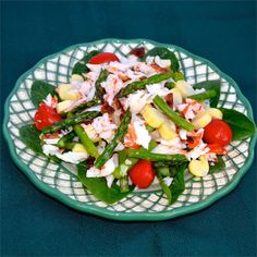 a green plate filled with salad on top of a blue table