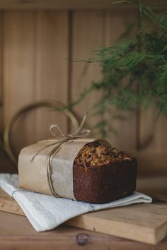 a piece of cake sitting on top of a wooden table next to a potted plant