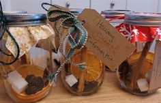 three mason jars filled with orange slices and marshmallows, tied with twine