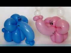 two balloons that look like elephants with faces on them, one is pink and the other is blue