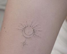 a small sun and moon tattoo on the back of a woman's thigh,