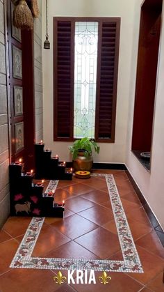 candles are lit on the floor in front of a window