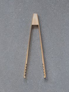 a pair of wooden spoons sitting on top of a gray table next to each other