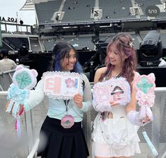 two girls holding up signs in front of an empty bleachers