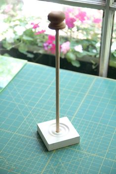 a small white object sitting on top of a green cutting board next to a window