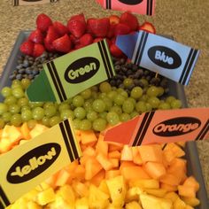 a tray filled with grapes, oranges and strawberries on top of a table