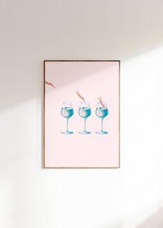 three wine glasses with straws in them sitting on a table next to a pink wall