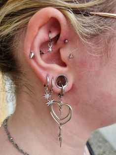 a close up of a person with some piercings on their ear and behind the ear