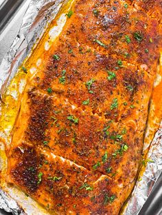 a piece of cooked salmon on tin foil with parsley sprinkled on top