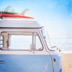 two surfboards on top of an old van at the beach