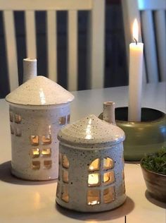 two white candle holders sitting on top of a table