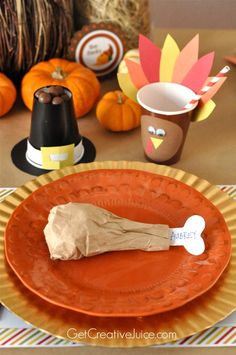 an orange plate topped with a piece of paper and a turkey hat on top of it