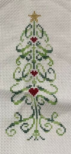 a cross stitch christmas tree on white fabric