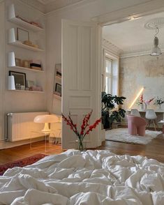 a bedroom with white walls and wooden floors