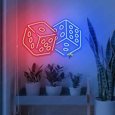 a neon sign with two dices on it next to some houseplants and a potted plant