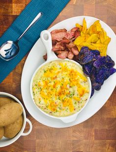 a white plate topped with food next to potato wedges and potatoes on a wooden table