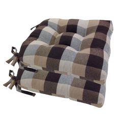 a brown and white checkered pillow with tassels