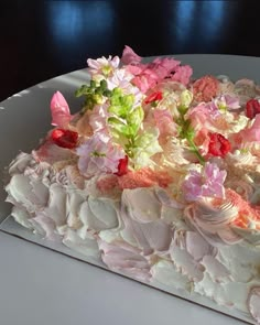 a white cake with pink and green flowers on it