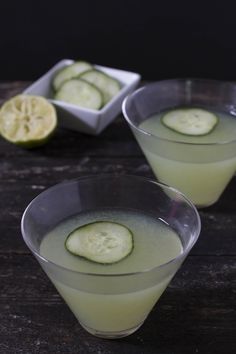 two glasses filled with liquid and cucumber slices