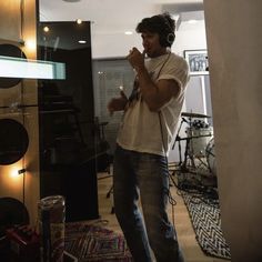 a man standing in a room with headphones on