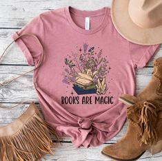 Books are magic Shirt,  Crystals Shirts, Bookish tshirt, Book Lover Gifts Please read entire listing before purchasing! This listing includes Tank tops, unisex shirts and sweatshirts to make your shopping experience easy! Heather Colors Cotton Poly Blend Solid Color Shirts 100% Cotton Sweatshirt Gildan 50/50 Cotton/Poly Blend DTG printing Colors vary per item Shipping time: We do our best to get all orders out within 3 to 5 business days. Holiday shipping times can vary. Care instructions: Machi Bookish T-shirt With Funny Print, Pink Crew Neck T-shirt With Bookish Style, Bookish Tshirt, Books Are Magic, Book Lover Gifts, Solid Color Shirt, Dtg Printing, Book Addict, Fantasy Books