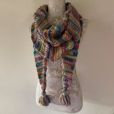 a multicolored scarf is hanging on a mannequin