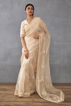 Beige saree with dori embroidery and lace border. Paired with padded and tassel detailed blouse.
Components: 2
Pattern: Embroidered, Printed, Quilted
Type Of Work: Dori, Hand Block
Neckline: Cutwork
Sleeve Type: Cutwork
Fabric: Handwoven Chanderi, Cotton Silk, Silk Organza
Color: Beige
Other Details: 
Tassel back blouse and saree border
Dori work
Occasion: Wedding,Bride - Aza Fashions Dori Embroidery, Dori Work, Scallop Border, Block Print Saree, Padded Blouse, Border Saree, Embroidery Hand, Blouse For Women, Hand Block Print